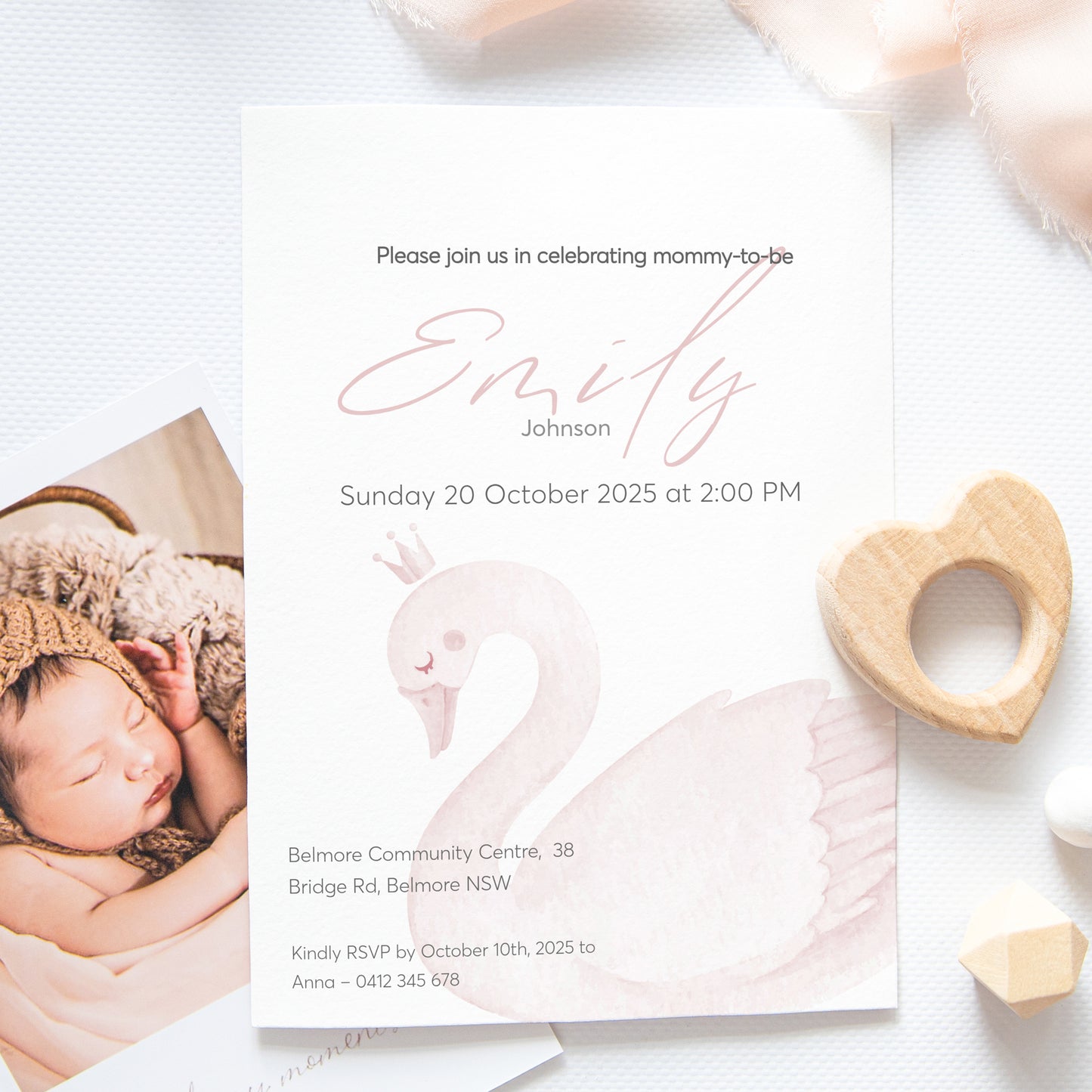 Baby shower invitation with photo of a baby and a swan design, featuring the name Emily Johnson.