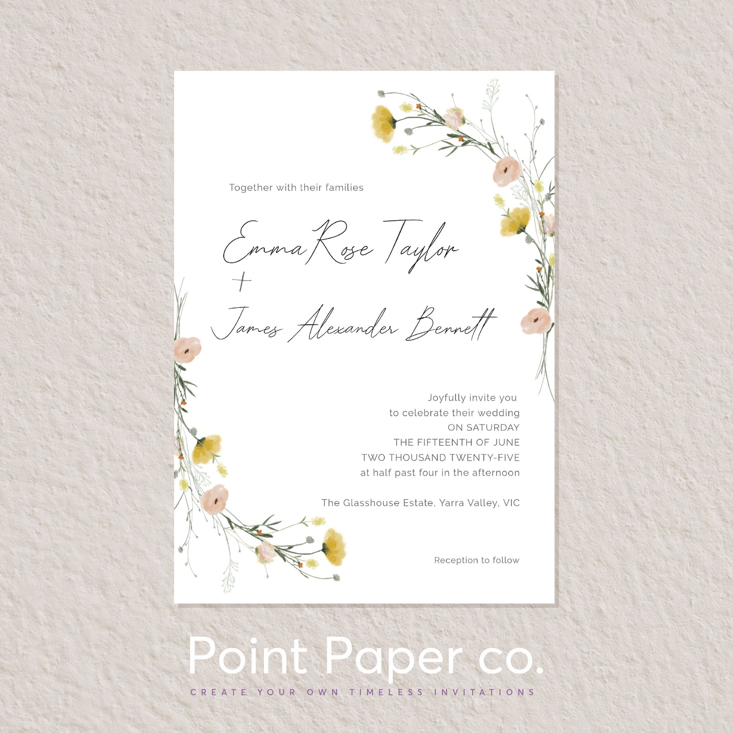 A vertical wedding invitation card with a white background, elegant black script names, and delicate floral watercolor illustrations in soft pink, yellow, and green at the top and bottom corners. The card is centered on a light beige textured wall, with the text 'Point Paper co.