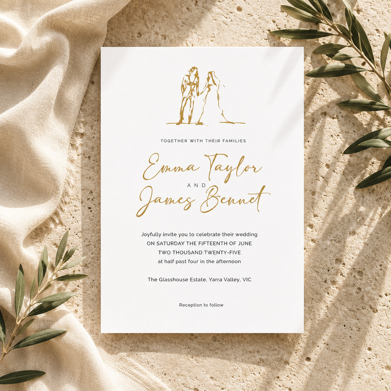 A wedding invitation card with elegant gold typography and a minimalist line drawing of a bride and groom, styled flat-lay on a textured beige stone surface with draped cream fabric and olive branches.