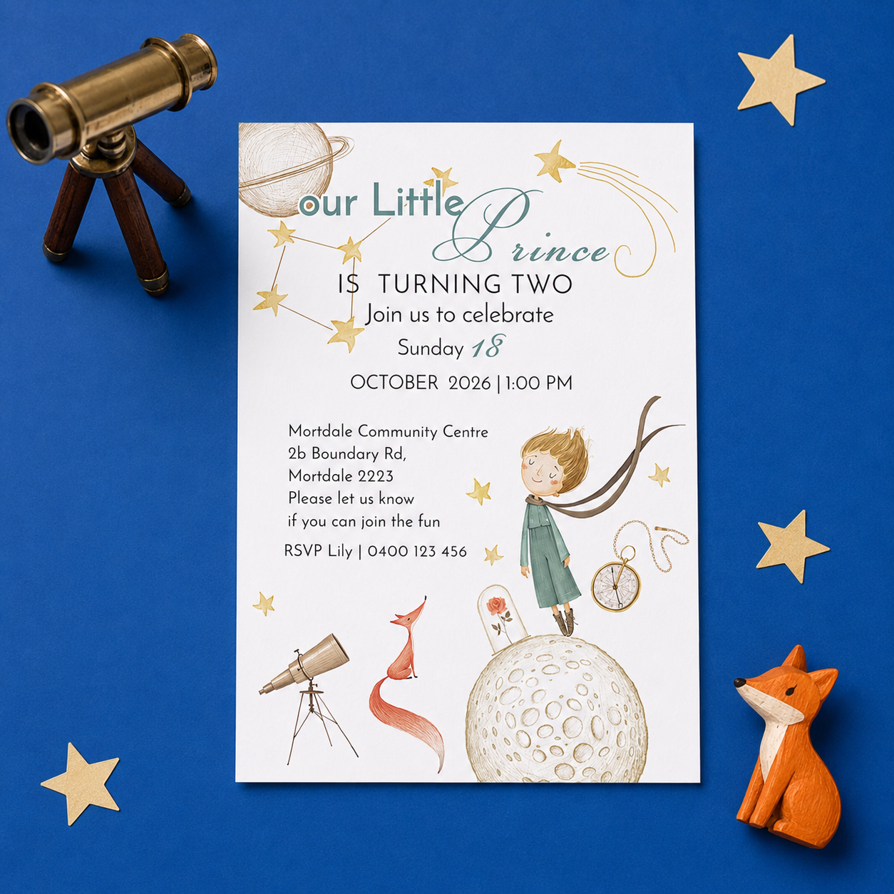 A children's birthday invitation card styled in a flat lay on a blue background, surrounded by a brass telescope, gold star cutouts, and an orange fox figurine. The invitation features whimsical space-themed illustrations including a boy on the moon, a rocket, a fox, and constellations.
