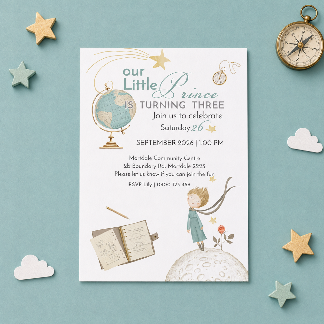 A styled flat-lay of a children's third birthday invitation card on a light blue background, surrounded by decorative props including wooden stars, a compass, and paper clouds. The invitation features whimsical illustrations of a globe, a child on a moon, and an open sketchbook.